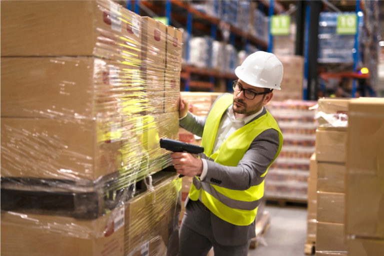 A man scanning the barcode on a freight shipment.